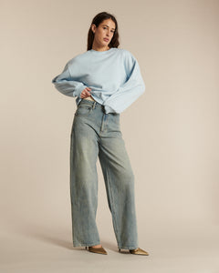 Jean femme en denim bleu clair 100 % coton, coupe large et droite, offrant un confort décontracté et une silhouette fluide adaptée à toutes les morphologies.