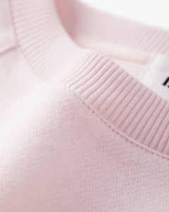 pull en coton rose pastel avec col rond côtelé, maille douce et confortable adaptée à un style décontracté féminin