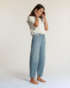 Jean femme en denim léger bleu clair, coupe droite légèrement ample, taille haute avec matière 100% coton offrant un confort adapté à toutes les morphologies.
Jean ballon JEMMA en denim bleu clair porté par le mannequin en pied, vue de trois quarts, coloris IN 27.