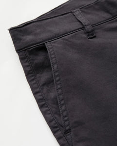 Détail d’un jean brun en coton stretch au tissu épais, coupe droite avec poches plates et ceinture avec passants, conçu pour s’adapter à toutes les morphologies.