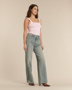 Jean femme en denim bleu délavé, coupe large et droite, matière 100 % coton, offrant un tombé fluide et un confort adapté à toutes les morphologies.
Porté par le mannequin de face