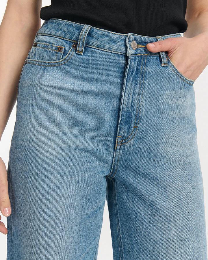 Jean femme en denim 100% coton bleu clair, coupe ballon avec taille haute ajustée, offrant confort et style décontracté adapté à toutes les morphologies.