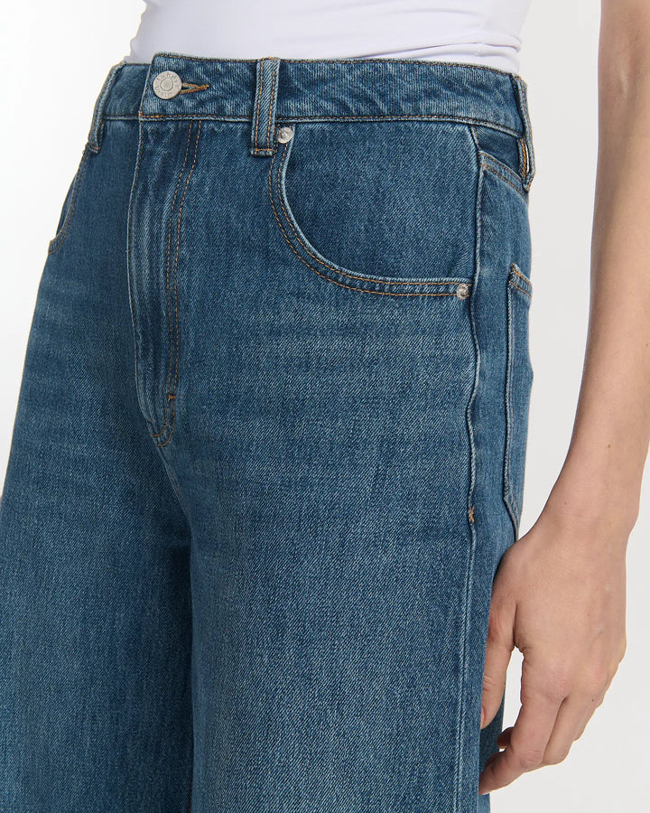 Jean en denim bleu moyen avec une coupe large et droite, en coton épais, conçu pour s'adapter à toutes les morphologies féminines avec confort et style.