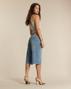 Jean en denim bleu clair 100 % coton avec coupe large et longueur midi, offrant une silhouette confortable et moderne adaptée à toutes les morphologies.