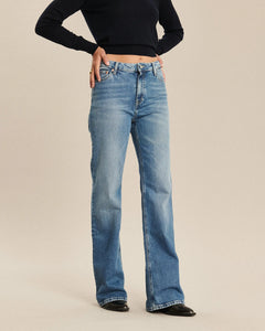 Jean en denim bleu rétro avec coupe bootcut, taille haute et ajustement confortable qui s’adapte à toutes les morphologies féminines.