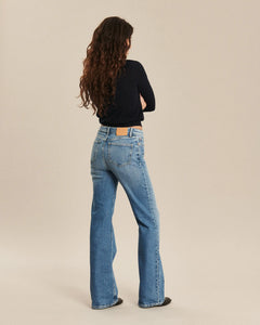 Jean femme en denim bleu rétro, coupe droite légèrement évasée, matière 100 % coton offrant un tombé fluide et adapté à toutes les morphologies.