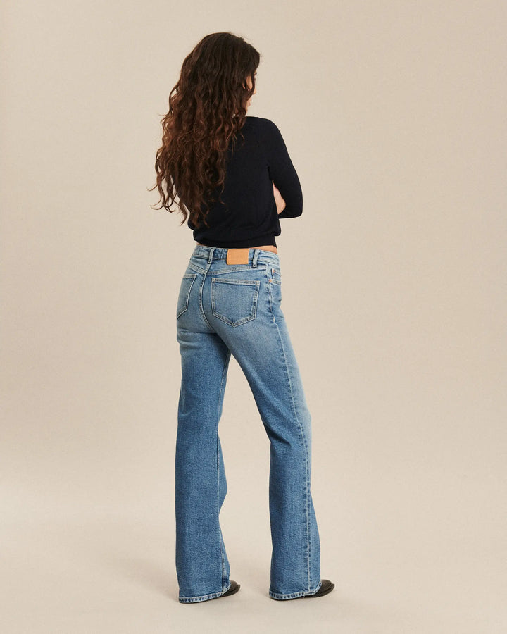 Jean femme en denim bleu rétro, coupe droite légèrement évasée, matière 100 % coton offrant un tombé fluide et adapté à toutes les morphologies.