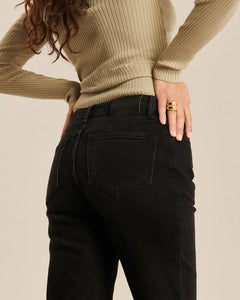 Jean en denim noir charbon coupe bootcut ajustée, matière 100% coton offrant une silhouette féminine et confortable qui s’adapte à toutes les morphologies.