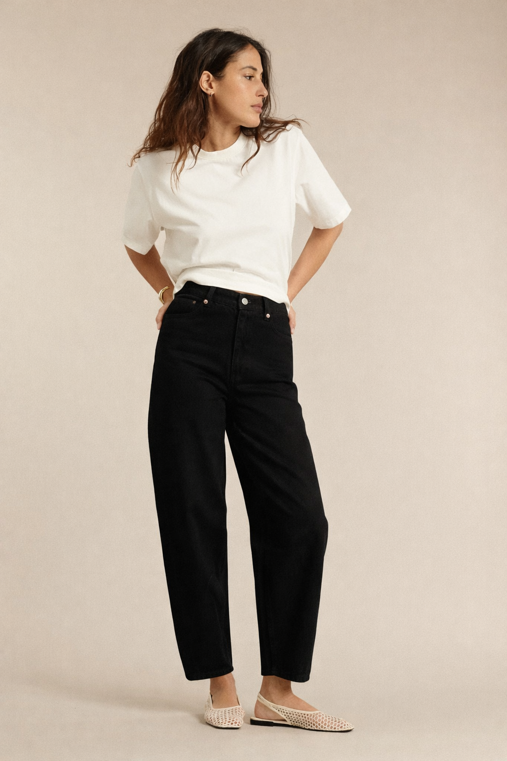 Jean femme en denim noir 100 % coton avec coupe ballon ample et taille haute, offrant un fit confortable et élégant adaptable à toutes les morphologies.
Porté par le mannequin de face