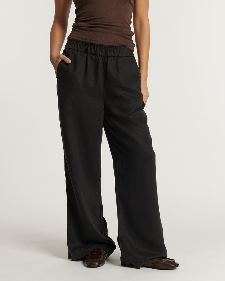 Pantalon large en tissu fluide noir avec taille élastiquée, coupe droite décontractée offrant confort et élégance, idéal pour un style femme polyvalent.