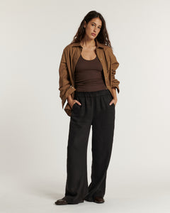 Pantalon large pour femme en tissu fluide marron foncé, coupe décontractée avec taille élastique pour un confort optimal adapté à toutes les morphologies.