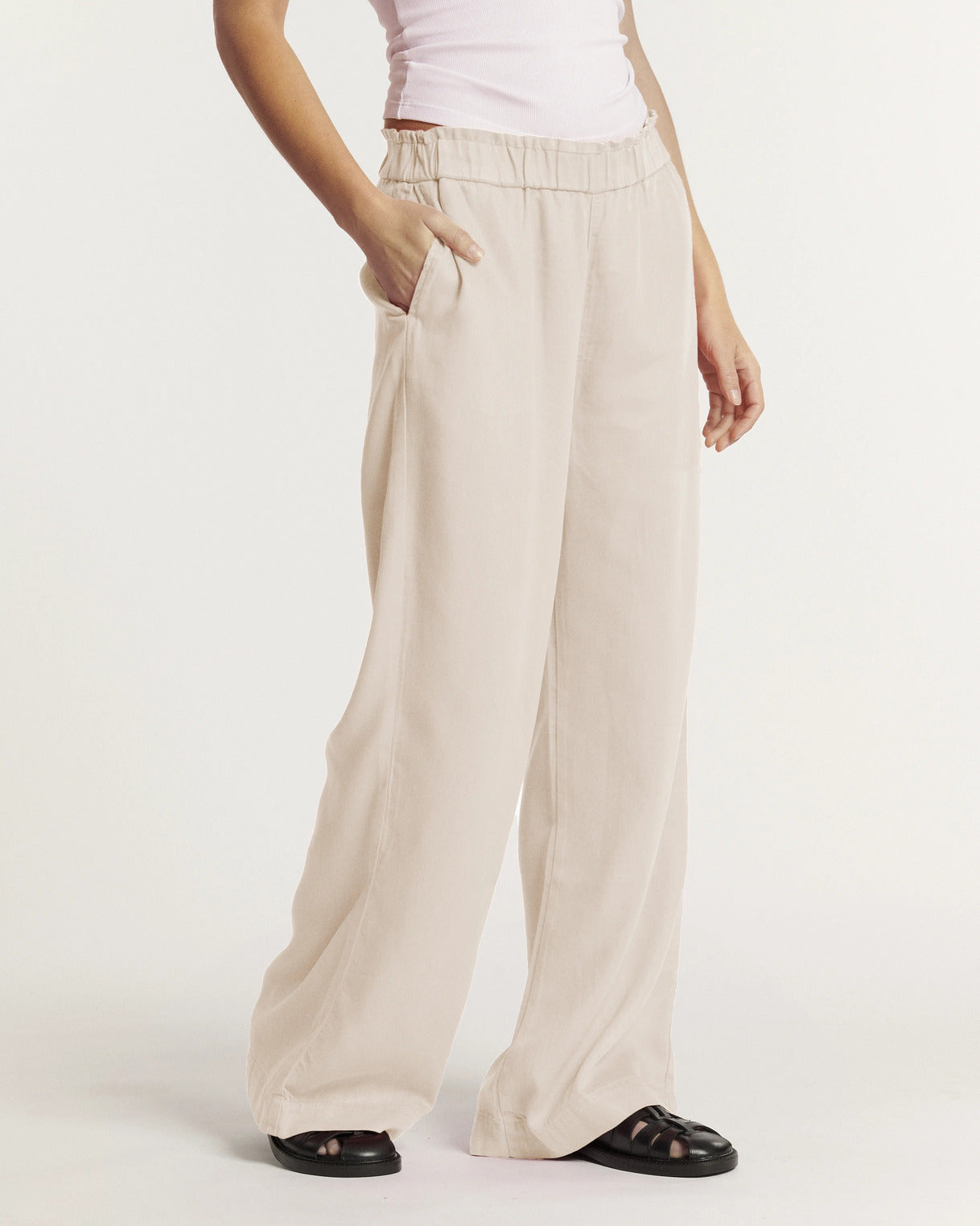 Pantalon fluide pour femme en tissu léger couleur écume, coupe large et droite avec taille élastiquée pour un confort adaptable à toutes les morphologies.