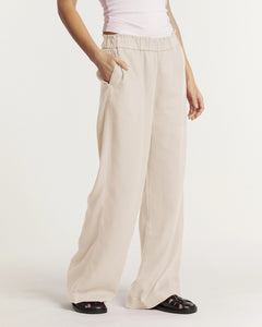 Pantalon fluide pour femme en tissu léger couleur écume, coupe large et droite avec taille élastiquée pour un confort adaptable à toutes les morphologies.