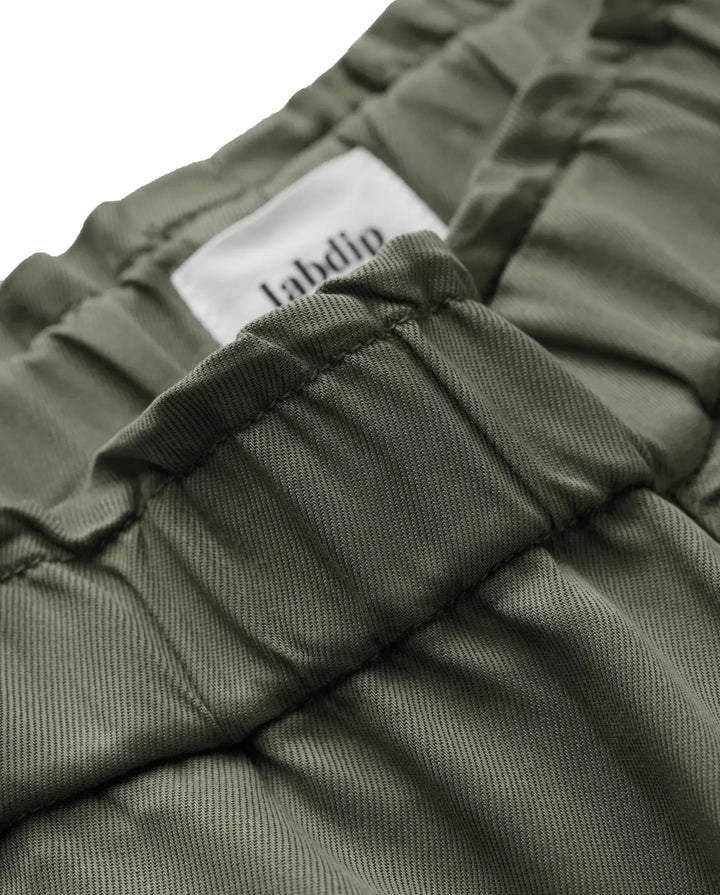 Détail d’un pantalon en tissu tencel kaki avec une taille élastiquée et une coupe confortable, idéal pour un jean femme alliant douceur et style décontracté.