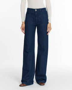 Jean denim brut bleu foncé en coton avec coupe large et droite, poches plaquées à l'avant, adapté à toutes les morphologies pour un style décontracté et confortable.