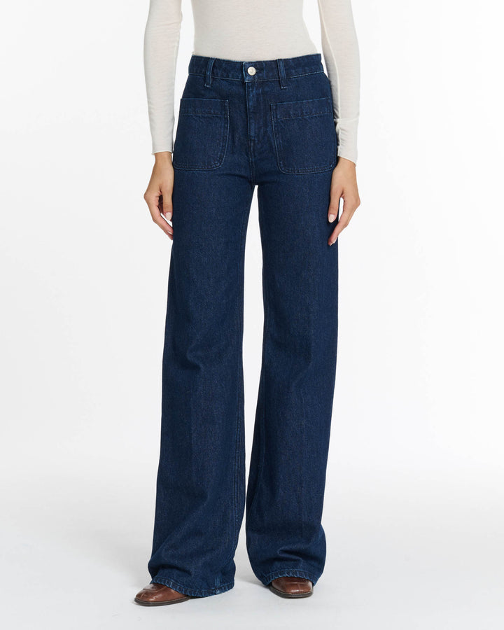 Jean denim brut bleu foncé en coton avec coupe large et droite, poches plaquées à l'avant, adapté à toutes les morphologies pour un style décontracté et confortable.
