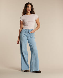 Jean femme en denim bleu clair, coupe flare ample, taille haute, matière en coton souple pour un confort optimal adapté à toutes les morphologies.