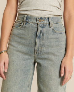 Jean en denim bleu clair avec un effet porté, coupe droite et taille haute, conçu pour s’adapter confortablement à toutes les morphologies féminines.