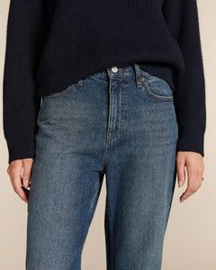 Jean droit en denim bleu moyen avec une coupe ajustée à la taille, matière en coton épais et aspect légèrement délavé, adapté à toutes les morphologies.