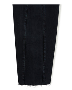 Morceau de jean en denim noir foncé, coupe ballon avec un effet légèrement évasé, tissu 100 % coton au toucher brut et bord inférieur effiloché pour un style décontracté.