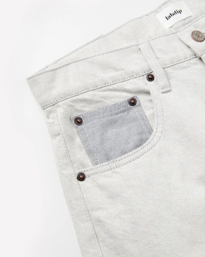 Jean femme en denim 100 % coton non teinté, couleur granit clair avec poche avant contrastée, coupe droite et ajustée, matière robuste et confortable.
