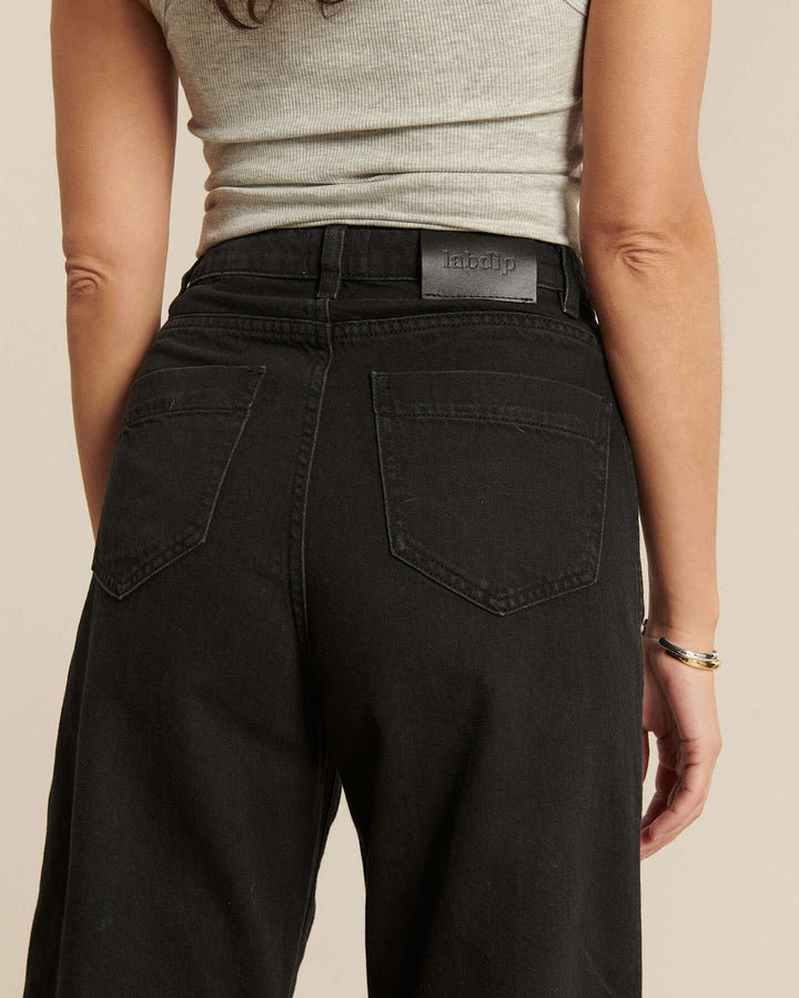 Jean en denim noir foncé 100% coton avec coupe large et taille haute, conçu pour s’adapter à toutes les morphologies féminines avec confort et style.