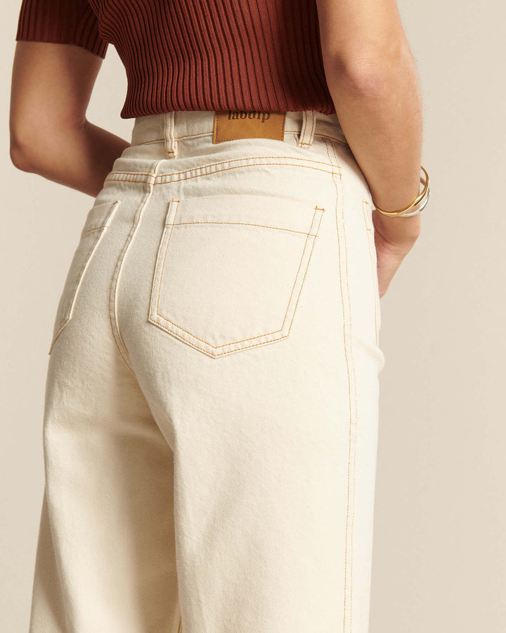 Jean en denim écru clair 100 % coton avec coupe large et taille haute, adapté à toutes les morphologies pour un style décontracté et confortable.