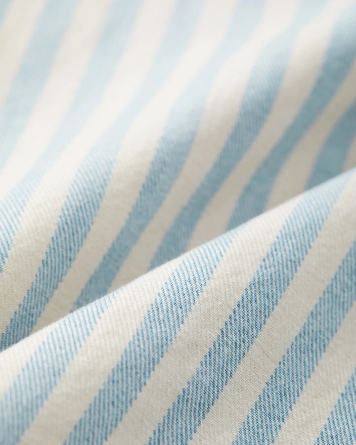 Tissu denim en coton rayé bleu clair et blanc, texture douce et légère idéale pour un jean femme confortable et ajusté aux formes variées.