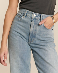 Jean en denim clair stone bleach avec coupe droite et taille haute, matière en coton douce adaptée pour femme, offrant un style estival et décontracté.
porté par le mannequin de face