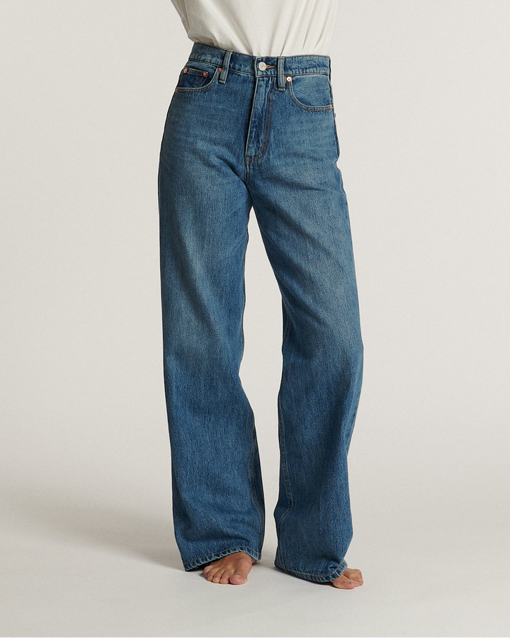 Jean en denim bleu moyen 100 % coton avec coupe droite et taille haute, conçu pour s’adapter confortablement à toutes les morphologies féminines.