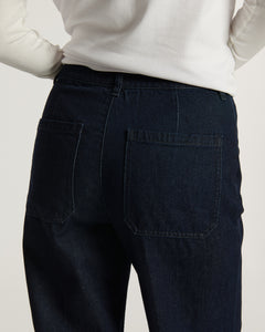Jean femme en denim brut bleu foncé, coupe droite avec poches arrière carrées, tissu 100 % coton offrant un ajustement confortable et naturel.