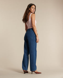 Jean femme en denim bleu moyen, coupe droite et fluide, matière 100 % coton, conçu pour s’adapter à toutes les morphologies avec un style intemporel et confortable.