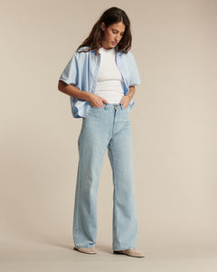 Jean en denim léger bleu clair 100 % coton avec coupe droite et légèrement évasée, idéal pour toutes les morphologies féminines, confortable et élégant.