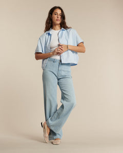 Jean femme en denim léger bleu clair, coupe droite et fluide, matière 100% coton offrant un ajustement confortable et adaptable à toutes les morphologies.