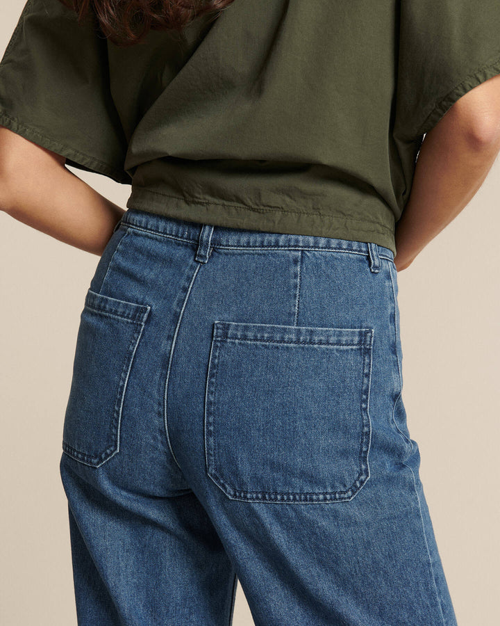 Jean en denim 100 % coton de couleur bleu moyen, coupe droite avec poches arrière carrées, ajusté et confortable pour toutes les morphologies féminines.