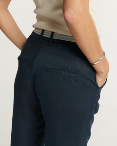 Pantalon femme marine en tissu Tencel fluide, coupe droite ajustée avec poches passepoilées à l’arrière, offrant confort et élégance décontractée.