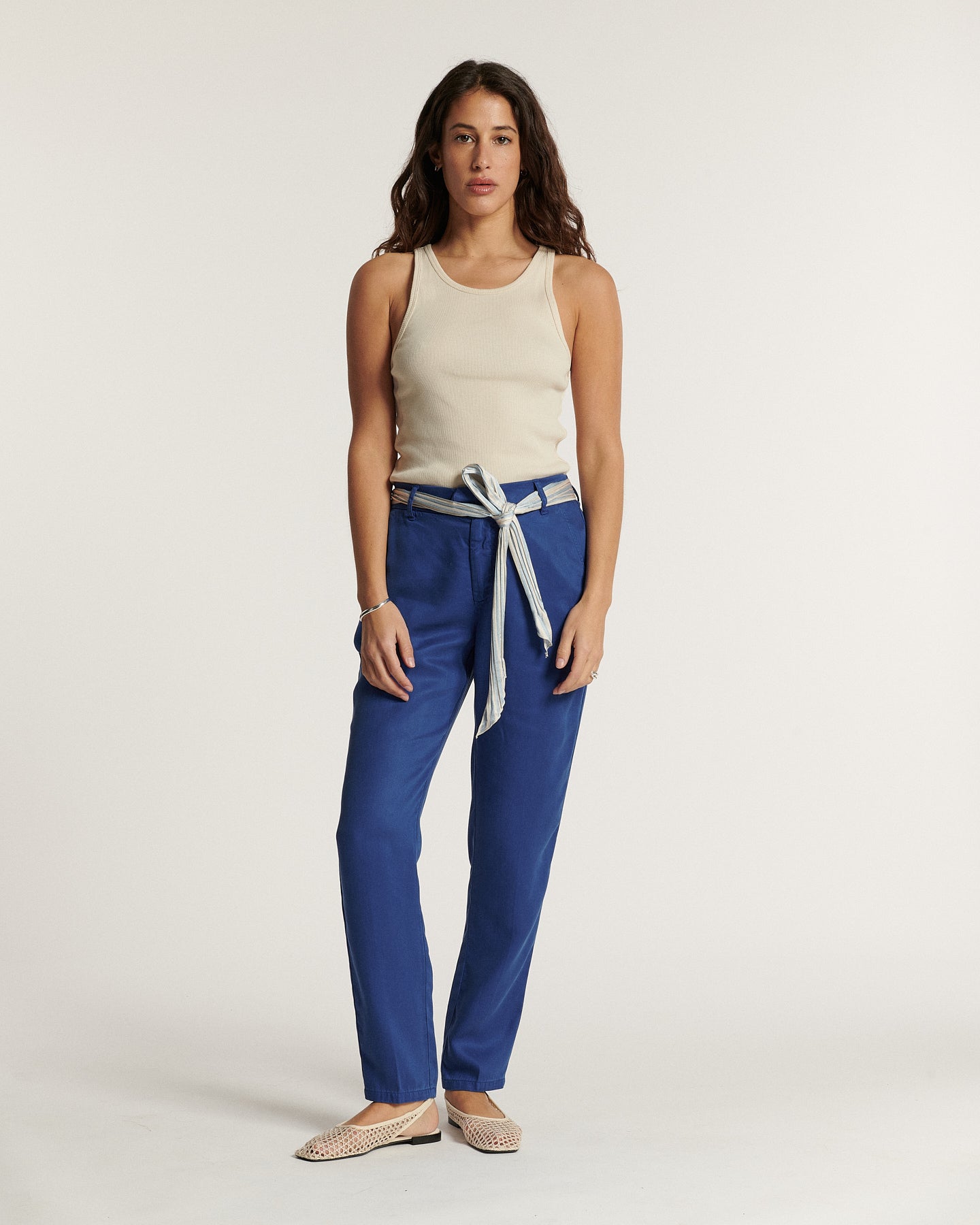 Pantalon en tencel bleu marine, coupe droite et ajustée, matière fluide et douce, ceinture intégrée nouée à la taille pour un style féminin et confortable.