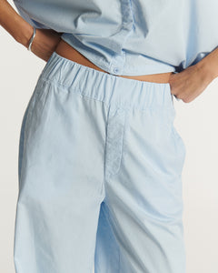 Pantalon en popeline légère bleu clair, coupe droite avec taille élastiquée pour un ajustement confortable, matière 100 % coton idéale pour l'été.